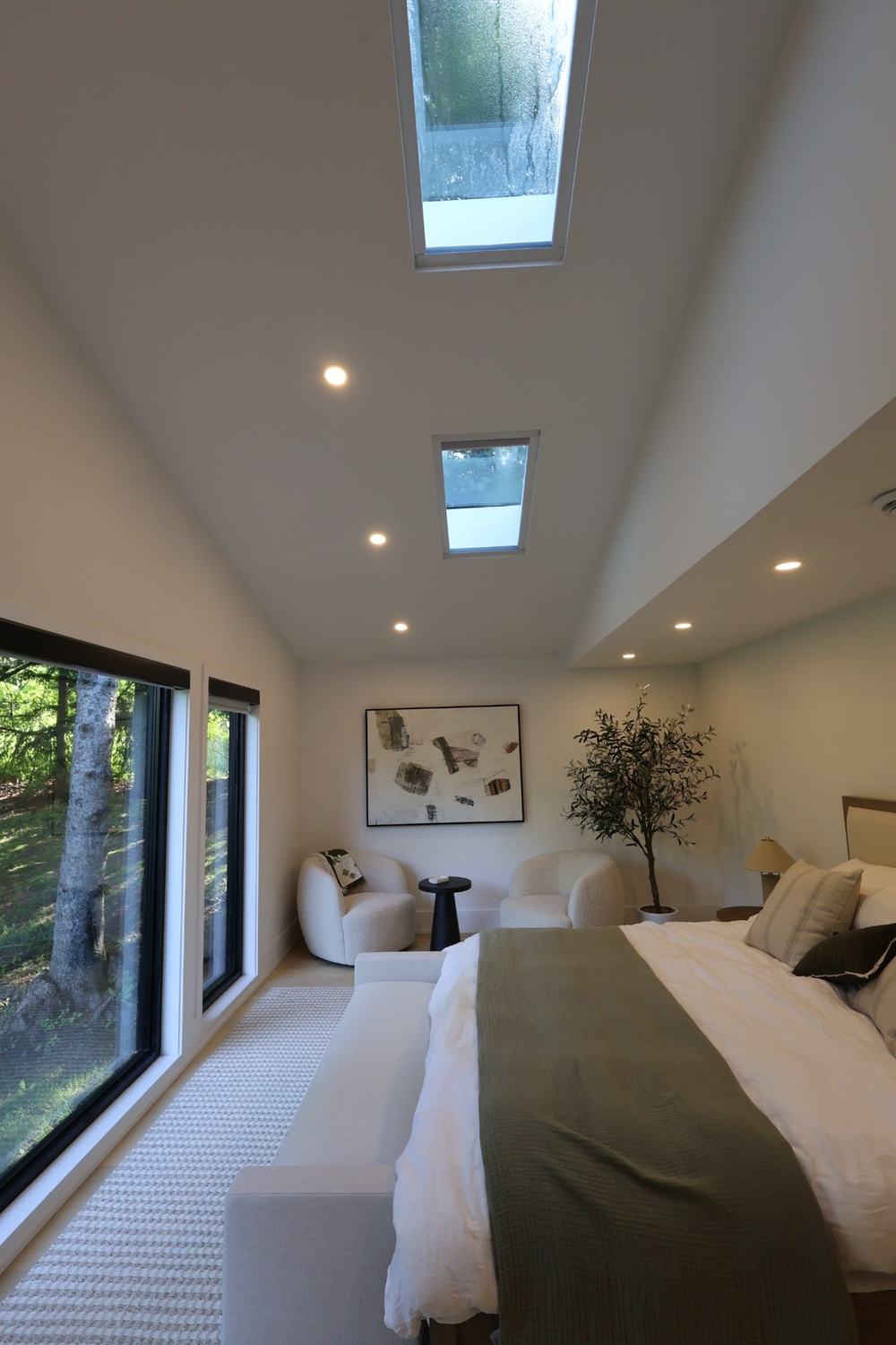 Vaulted bedroom with two skylights and floor-to-ceiling windows
