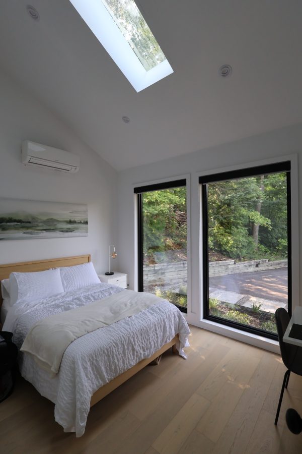 Bright bedroom under a skylight with wide-plank floors