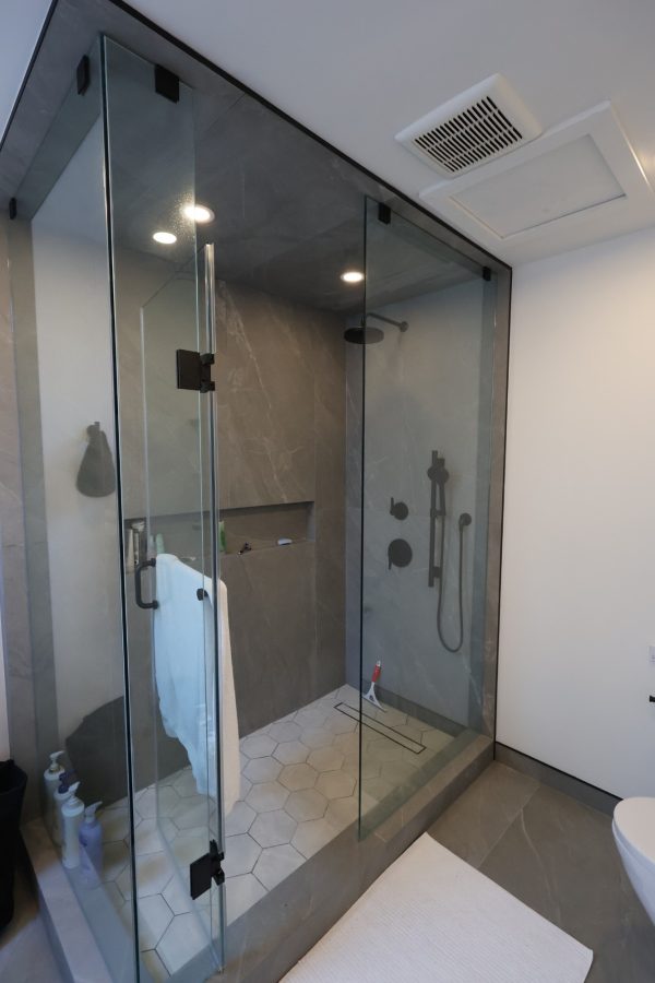 Frameless glass shower with porcelain walls