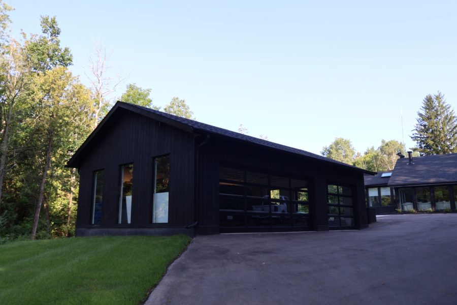 Dark-clad home with glass garage doors at dusk