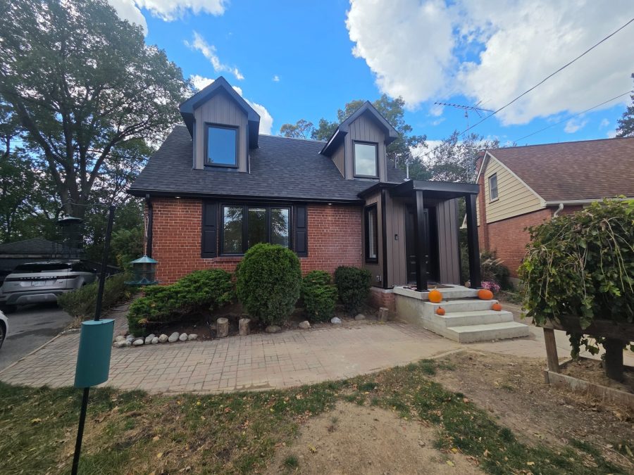 Brick home with dark dormers and a new front entry